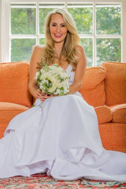 Işıl ışıl bir gelin zarif bir şekilde gelinliğiyle poz verir. Geleceğin özel gününün güzelliği, heyecanı ve neşe dolu zamansız gelin portrelerini çeker..