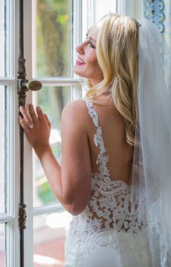 Işıl ışıl bir gelin zarif bir şekilde gelinliğiyle poz verir. Geleceğin özel gününün güzelliği, heyecanı ve neşe dolu zamansız gelin portrelerini çeker..