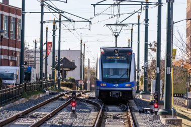 Charlotte, NC 'de gezginleri ve ziyaretçileri kalabalık mahallelerden, siluet manzaralarından ve hareketli sokaklardan geçirip şehri hızlı, temiz ve modern şehir ulaşımına bağlayan parlak bir tren yolu kayıyor..