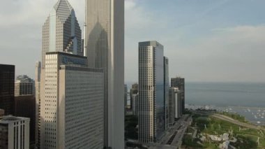 Şikago 'nun hava görüntüsü Michigan Gölü boyunca yığılmış gökdelenleri gösteriyor. Şehir merkezi boyunca akan nehir gibi dışa doğru genişliyor. İkonik mimariyi muazzam şehir enerjisiyle harmanlıyor..