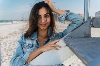 Göz kamaştırıcı melez bir bikini modeli güneşli bir plajda dinleniyor, parlayan tenini güneş öpüyor. Ferahlatıcı dalgaları, kendine güveni, zarafet ve güzellik saçan okyanus arkaplanını seviyor..