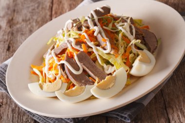 Beef heart with vegetables close-up on a plate. horizontal