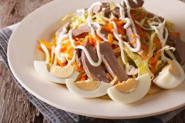 Salad from beef heart with eggs and vegetables close-up. horizon