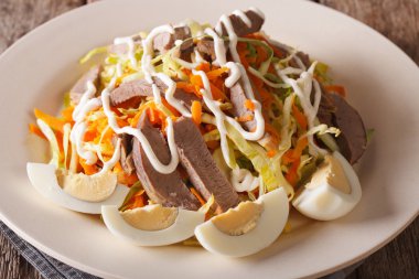 Salad from beef heart and vegetables close-up on the table. hori