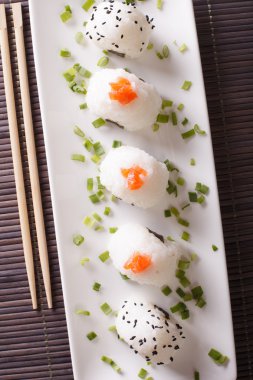 Japanese onigiri with salmon and sesame close-up. Vertical top v