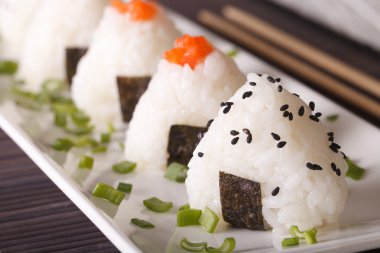 Japon yemekleri onigiri pirinç topları makro bir plaka üzerinde. Yatay