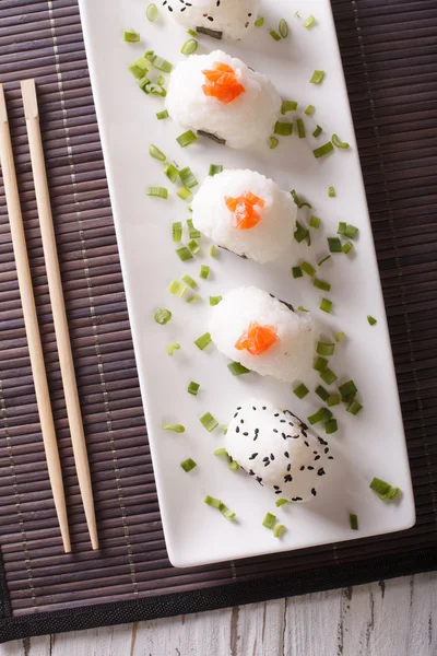 Onigiri rice balls close-up on a plate. Vertical top view — Zdjęcie stockowe