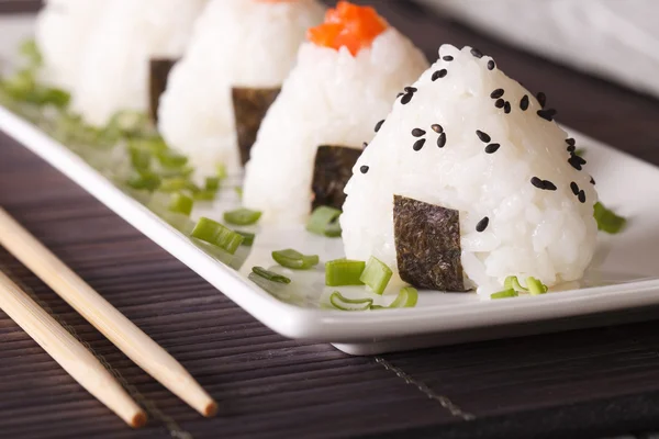 Onigiri ris bollar närbild på en tallrik. Horisontella — Stockfoto