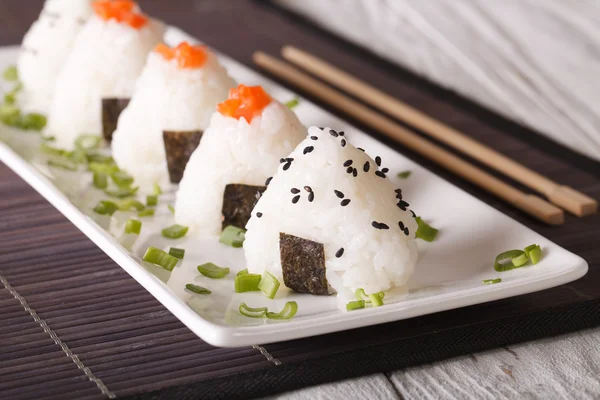 Onigiri bolas de arroz con salmón y sésamo primer plano. horizontal — Foto de Stock