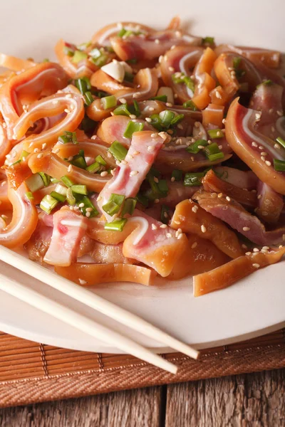 stock image pig ears with sesame seeds and green onions close-up on a plate.