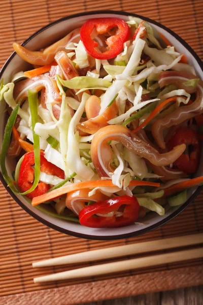 Pork ears salad with vegetables close-up on the table. vertical — Stock Photo, Image