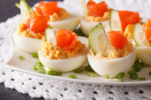 Leckere Eier gefüllt mit Lachs, Käse und Gurken Nahaufnahme — Stockfoto