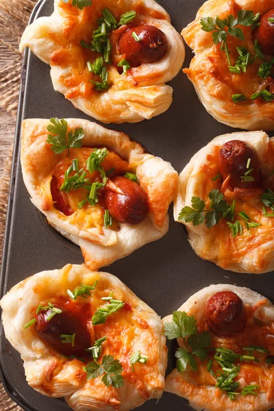 Buns with sausage, cheese and onion closeup in baking dish. vert — Stock Photo, Image