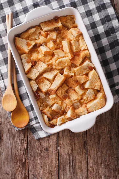 Frisch gebackener englischer Brotpudding im Backen. vertikale Ansicht von oben — Stockfoto