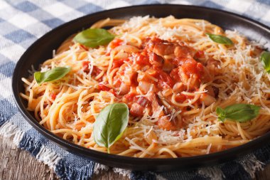 Amatriciana makarna bir tabak peynir ve fesleğen yakın çekim ile.