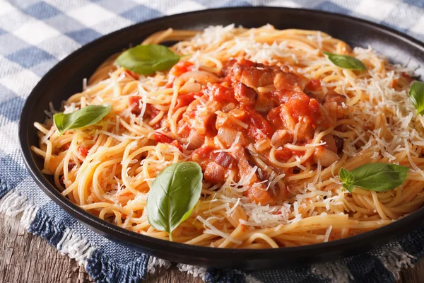 Amatriciana Spaghetti with cheese and basil close-up on a plate. — Stock Photo, Image