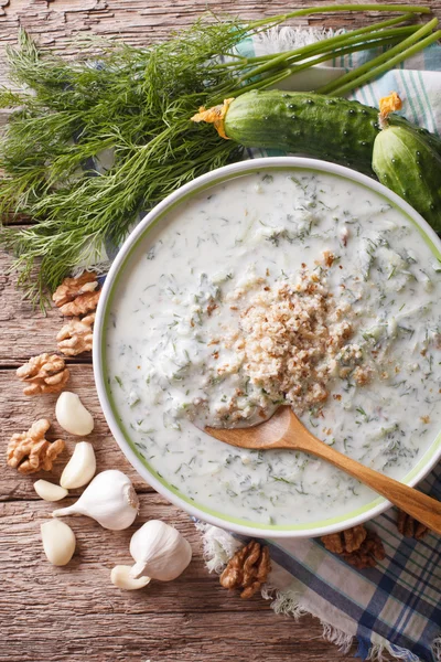 Cold soup tarator close up in a bowl and ingredients. vertical t — Stock Image Cold soup tarator close up in a bowl and ingredients. vertical t Royalty Free Stock Photos