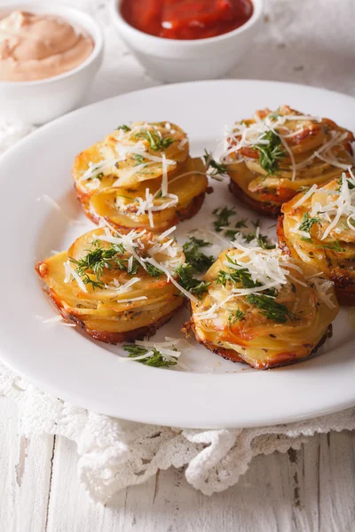 Patatas en rodajas al horno con parmesano de cerca en un plato. Vertica —  Fotos de Stock