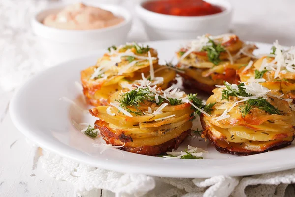 Batatas fatiadas assadas com parmesão close-up em um prato. horizonte — Fotografia de Stock
