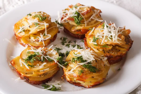 Patate al forno affettate con formaggio e aneto primo piano su un piatto . — Foto Stock