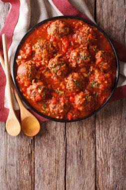 Meatballs with spicy tomato sauce on a plate on the table. verti clipart