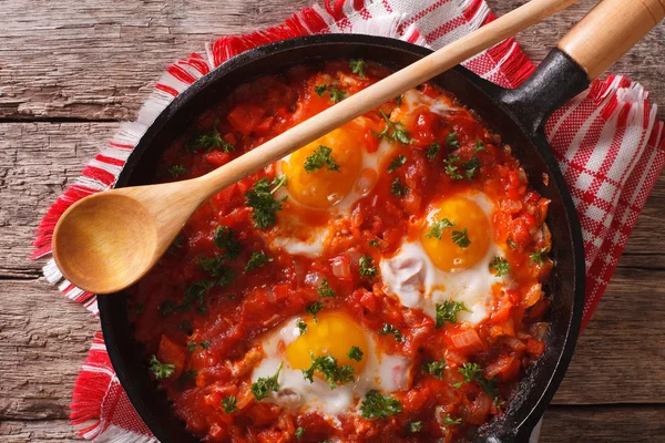 Shakshuka of fried eggs with tomato sauce in a pan close-up. hor — Stock Photo, Image