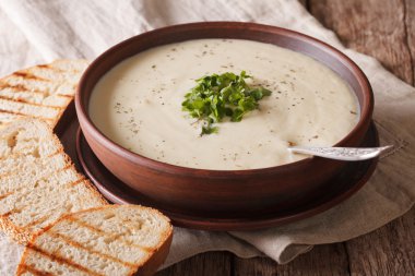 White vegetable cream soup close-up on the table. horizontal
