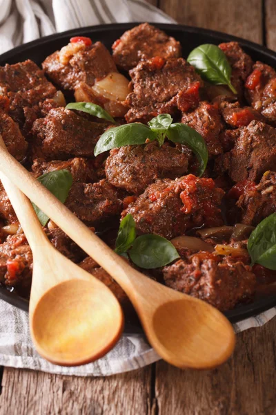 Würziges Rindfleisch mit Sauce und Basilikum in einem Gericht hautnah. vertikal — Stockfoto