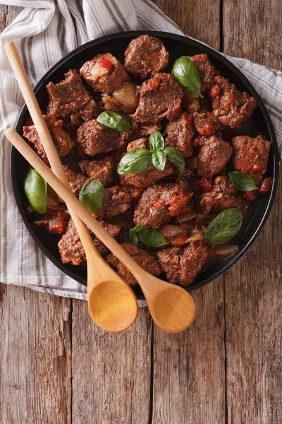 Stifado hovězí s omáčkou a čerstvou bazalkou zblízka v misce. vertikální t — Stock fotografie