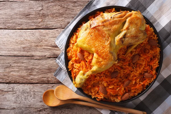 Kabsa of chicken with rice and vegetables on the table. Horizont
