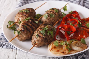 Bir tabak yakın çekim ızgara sebze ile Kefte kebap. Horizon