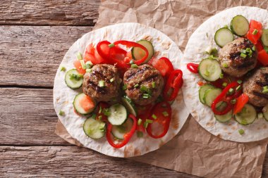 Grilled meat balls with fresh vegetables on a flat bread. Horizo clipart