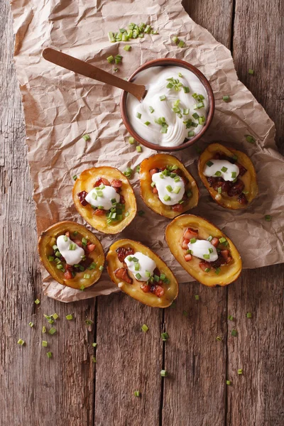 Potato skins with cheese, bacon and sour cream on the table. ver — Stock Photo, Image