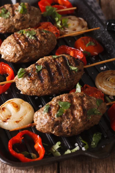 Kyufta Kebab z grillowanymi warzywami zbliżenie na patelni grilla. Ver — Zdjęcie stockowe