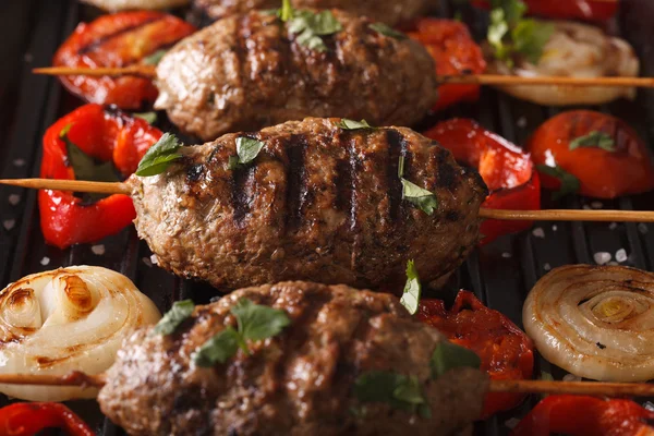 Kyufta kebab zöldségekkel makró egy grill serpenyőben. Vízszintes — Stock Fotó