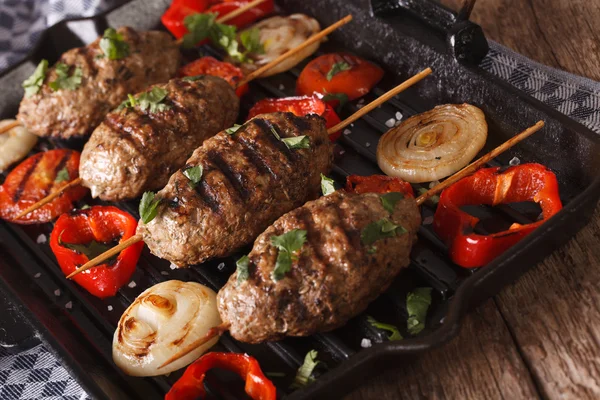 Kyufta kebab zöldségekkel közelről egy grill serpenyőben. horizonta — Stock Fotó