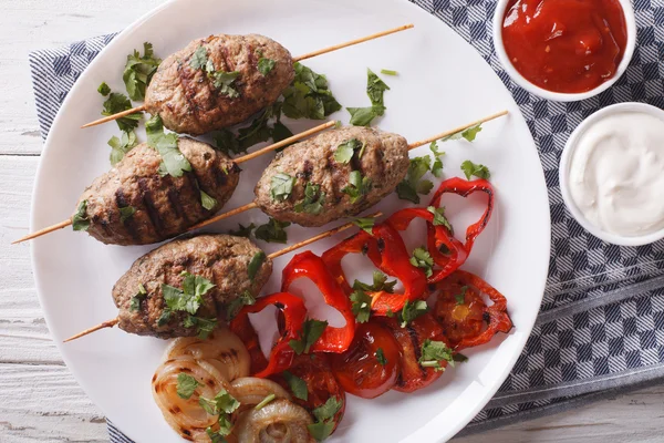 Kofta kebab s grilovanou zeleninou na talíři s omáčkou — Stock fotografie