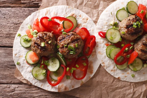 Grillade köttbullar med färska grönsaker på ett platt bröd närbild — Stockfoto