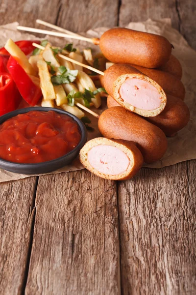 Corn dogi, frytki i ketchupem na stole. Pionowe — Zdjęcie stockowe