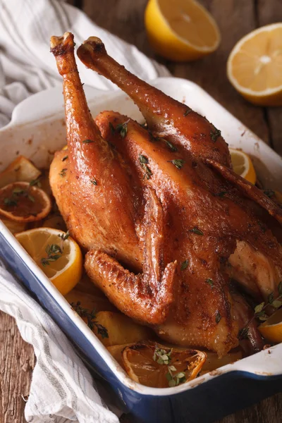 Whole chicken with lemon baked in a baking dish closeup. Vertica — Stock Photo, Image