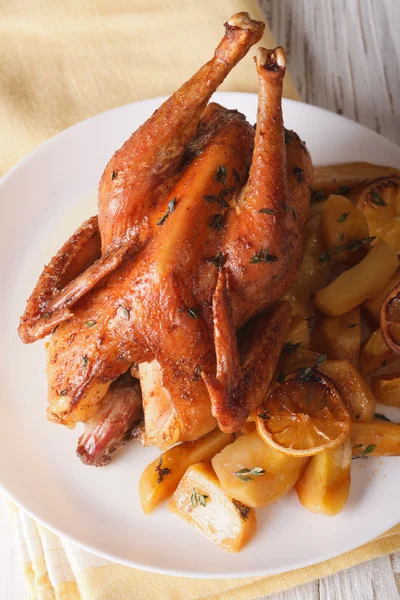 Whole baked chicken with lemon and thyme closeup on a plate. ver — Stock Photo, Image