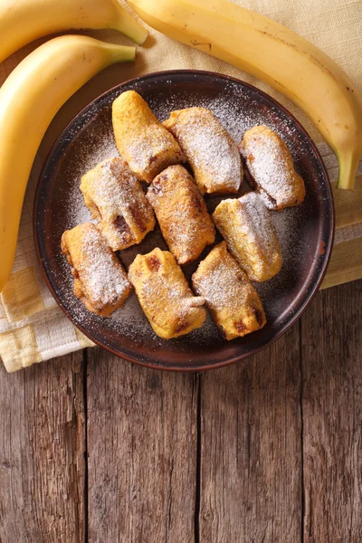 Bananes frites en pâte dans une assiette. Vue verticale du dessus — Photo