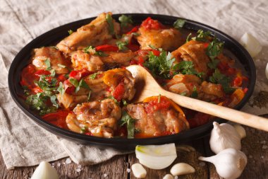 Chicken stew with a tomato, onion and pepper close-up. horizonta clipart
