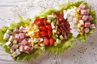 Tasty American Cobb salad close-up on a plate on the table. Hori clipart