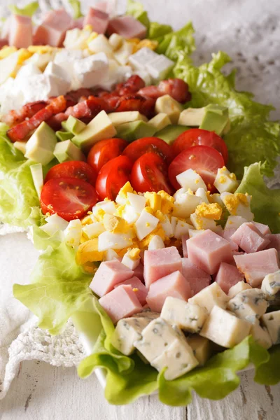 Salade de Cobb tranchée en gros plan sur une assiette. Vertical — Photo