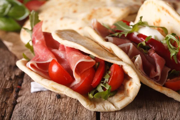 Italiensk piadina tunnbröd fylld med skinka och grönsaker i närheten- — Stockfoto