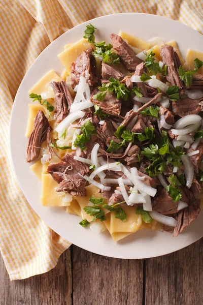 Asian beshbarmak - noodles with lamb and onion close-up. Vertica — Stock Photo, Image