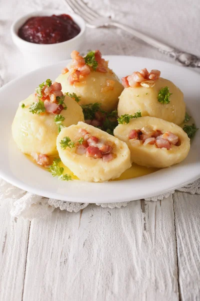 Potato dumplings stuffed with meat close up and lingonberry sauc — Stock Photo, Image