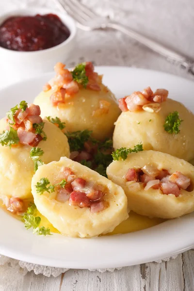 Potato dumplings stuffed with ham and onion close-up and lingonb — Stock Photo, Image