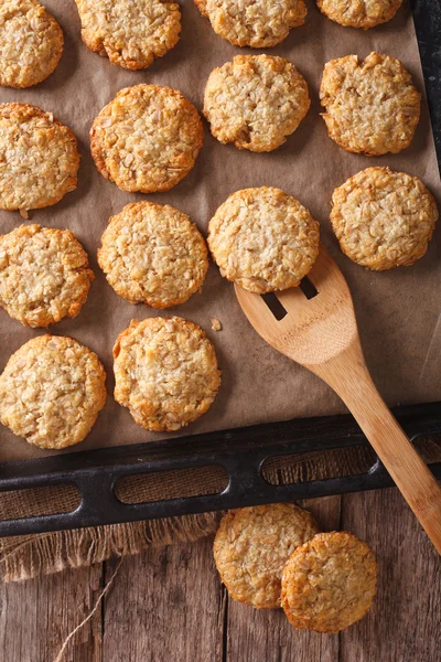 Anzac biscuits close up on a baking sheet. vertical view from ab — Stock Photo, Image